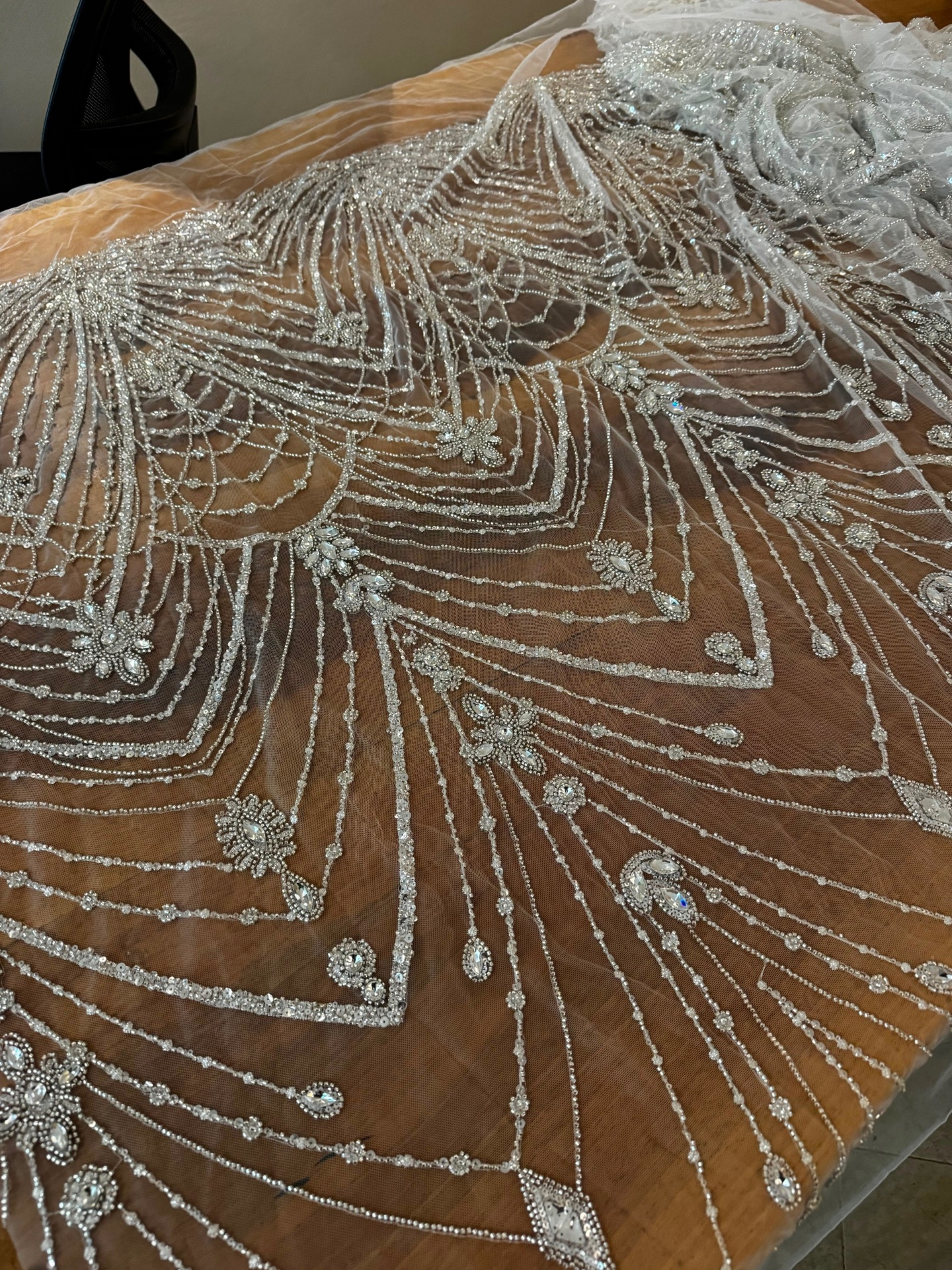 Close up of delicate lace hand-stitching on ivory silk